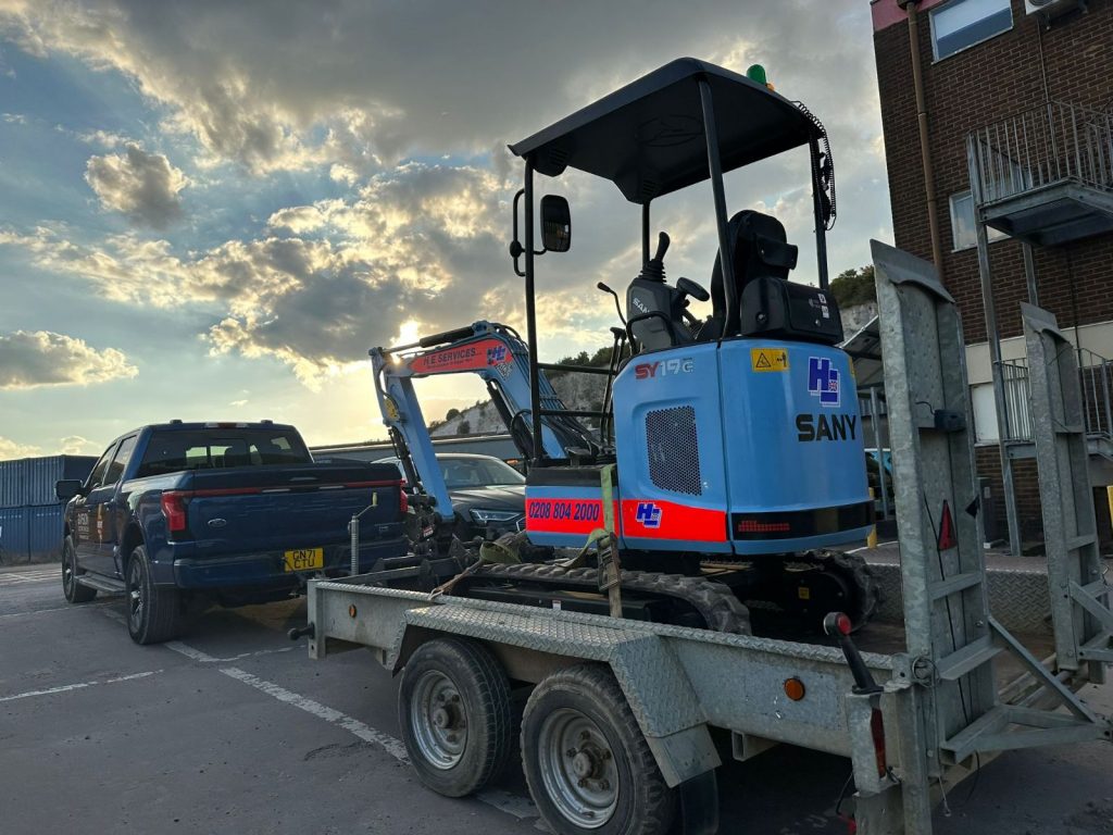 Sany SY19 electric digger being trailed by Ford F150 electric truck.